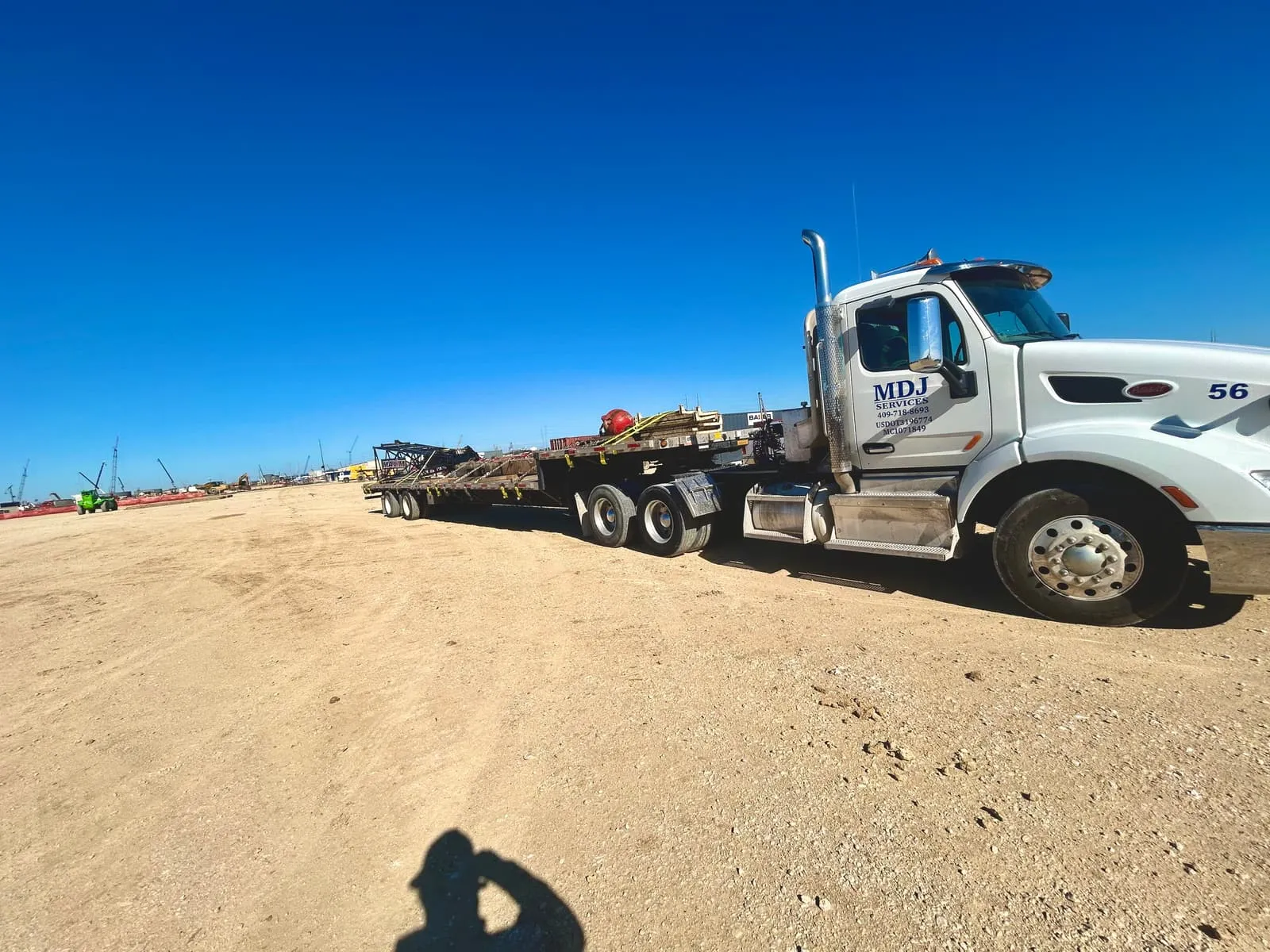 MDJ Services step deck trailer on a large industrial construction site on the Gulf Coast
